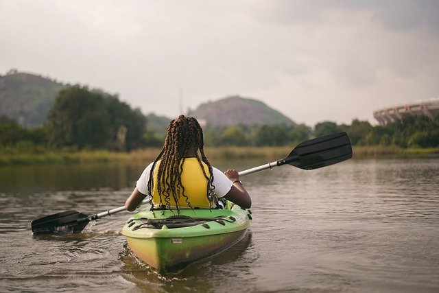 person kayaking on lake