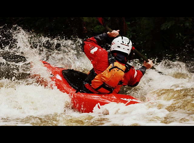 whitewater kayaker in rapids with white kayak helmet